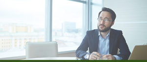Business man sitting at a table looking out the window