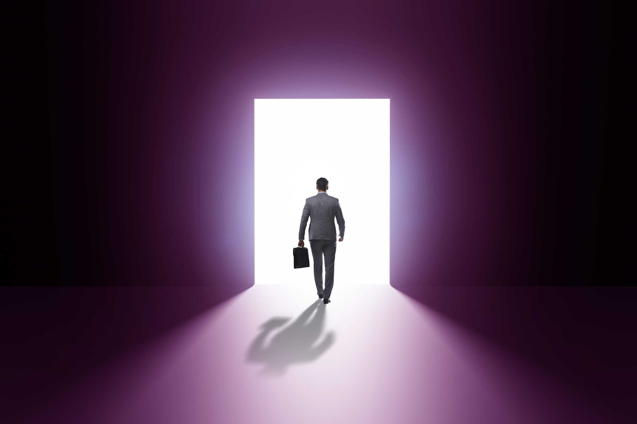 Businessman entering backlit door in escape concept